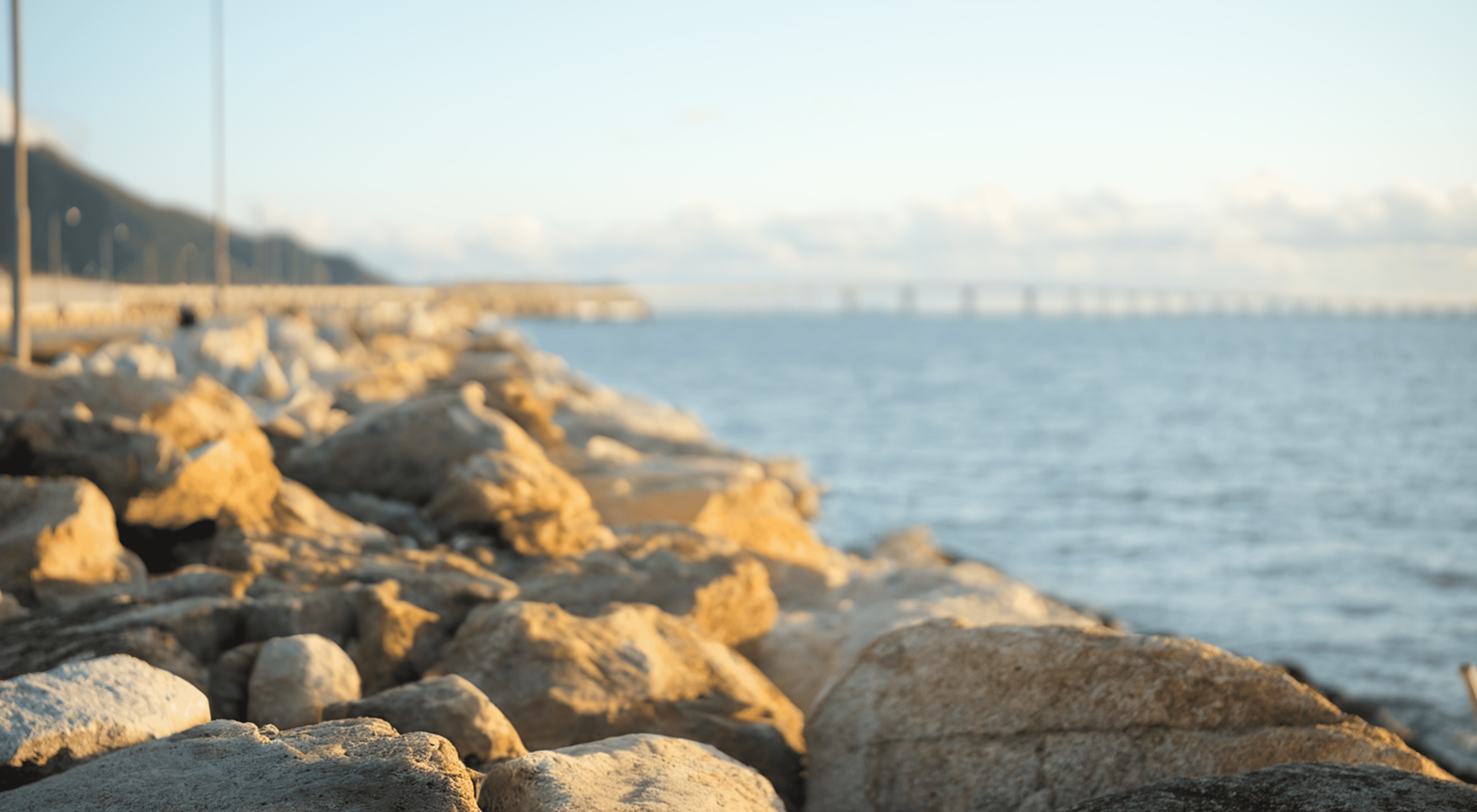 A musician playing the guitar on a rocky beach